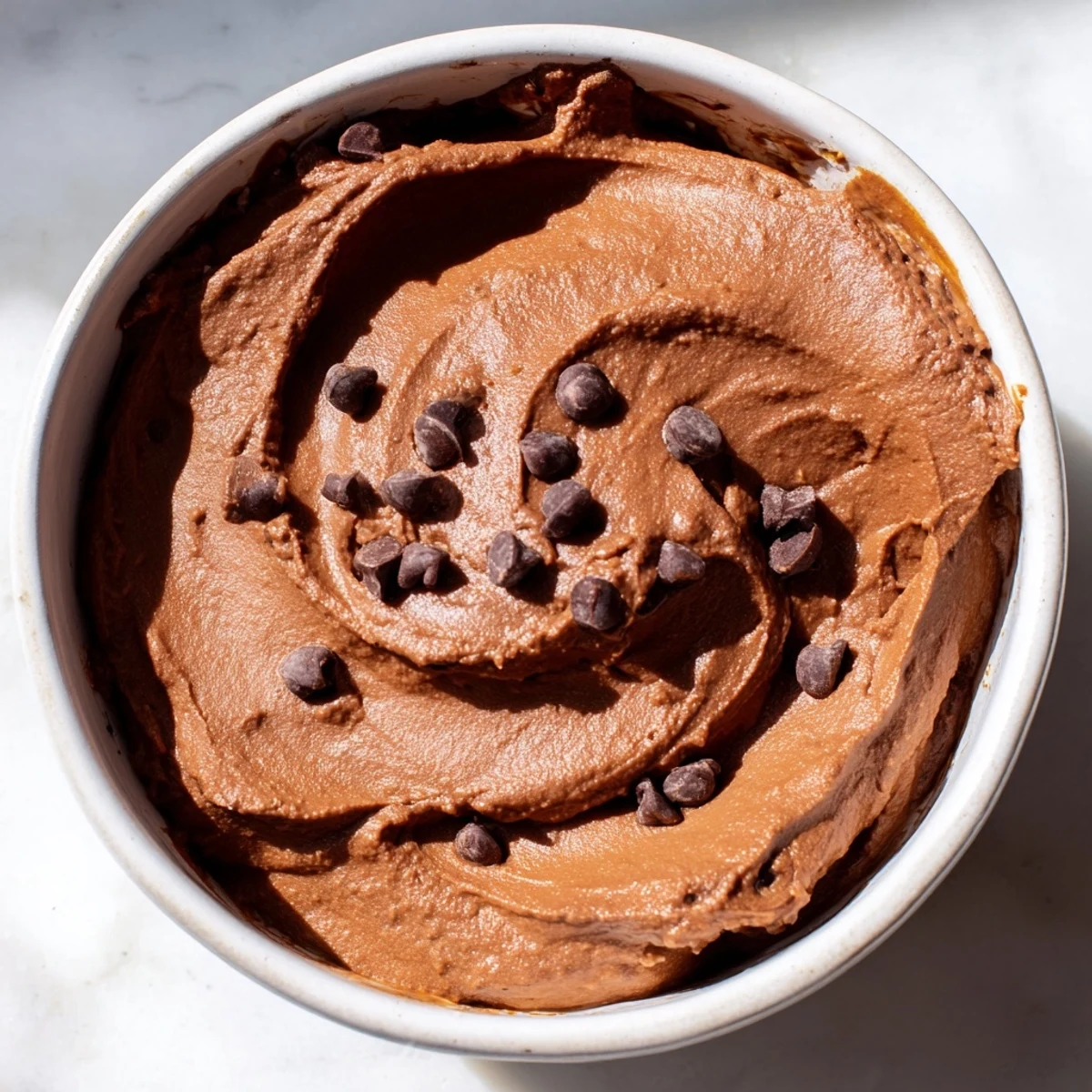 Smooth and creamy chocolate hummus, perfect for dipping apple slices, ready to savor.