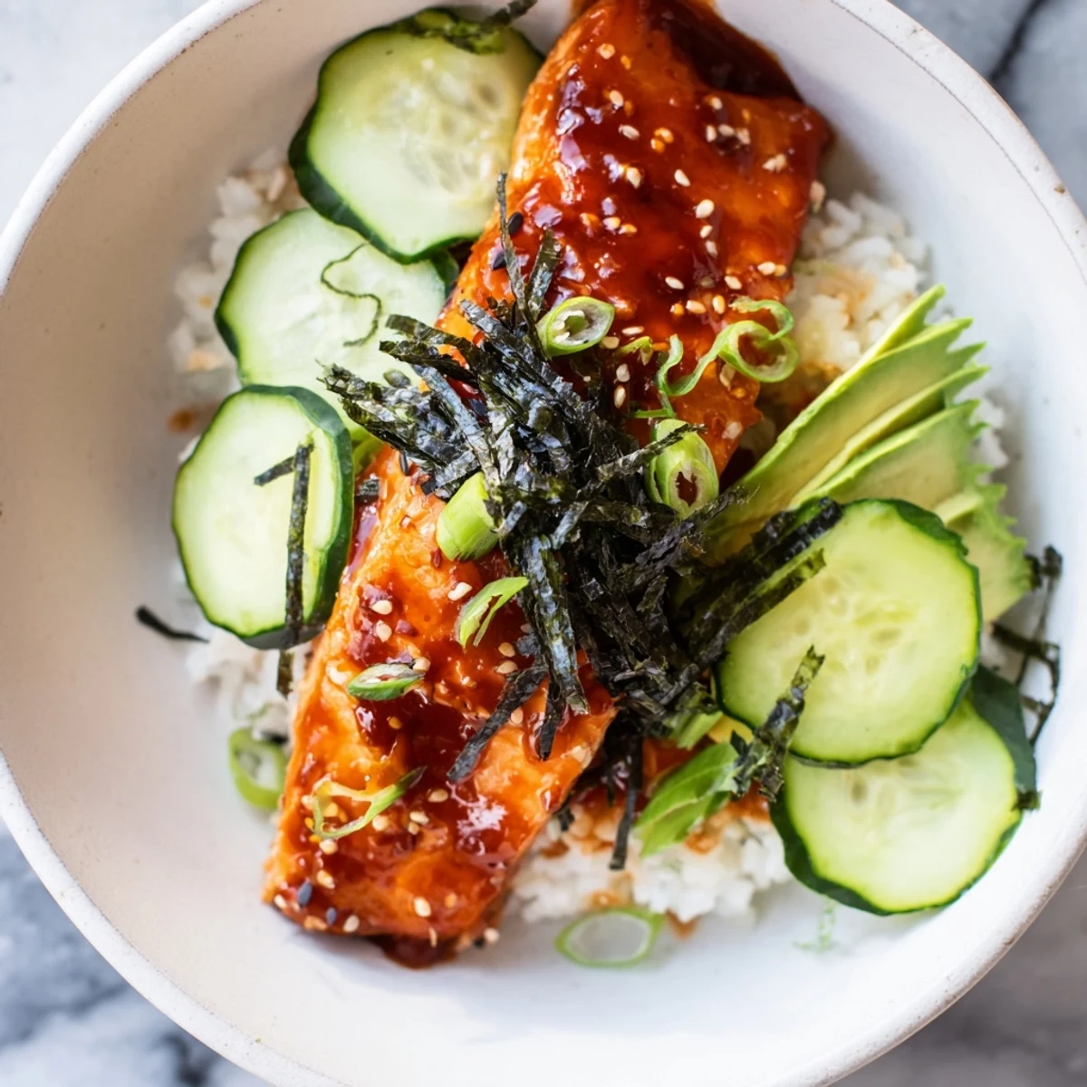 Emily Mariko-inspired salmon bowl: glistening, glazed salmon over rice, with colorful veggies for a vibrant dish.