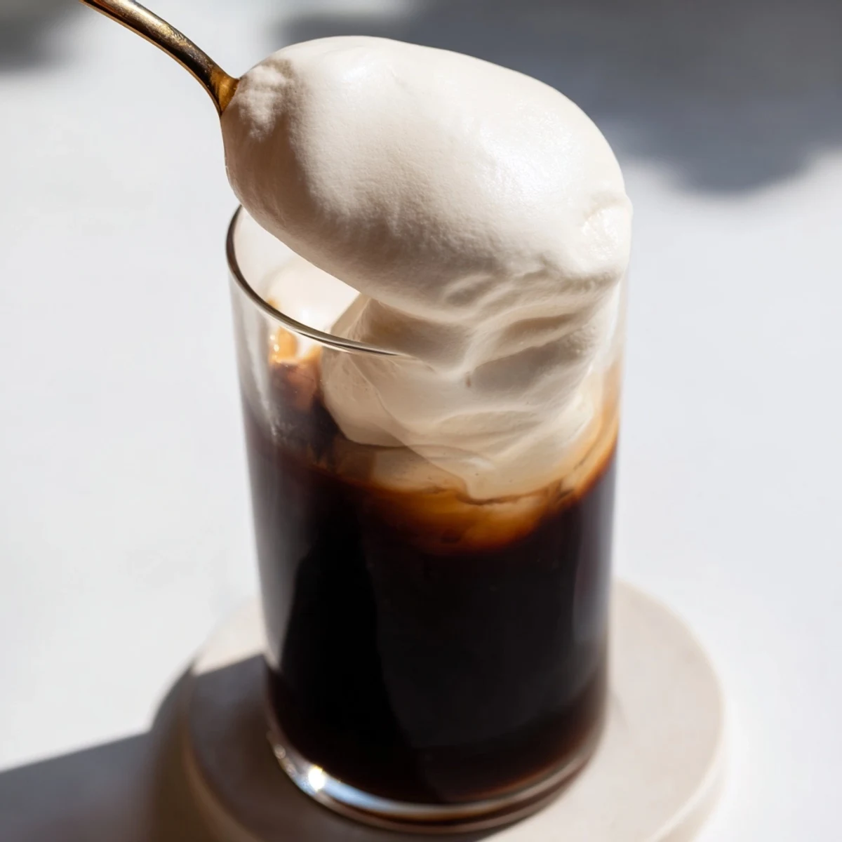 Fluffy Starbucks cold foam topping fresh iced coffee, swirled and ready to enjoy on a hot day.