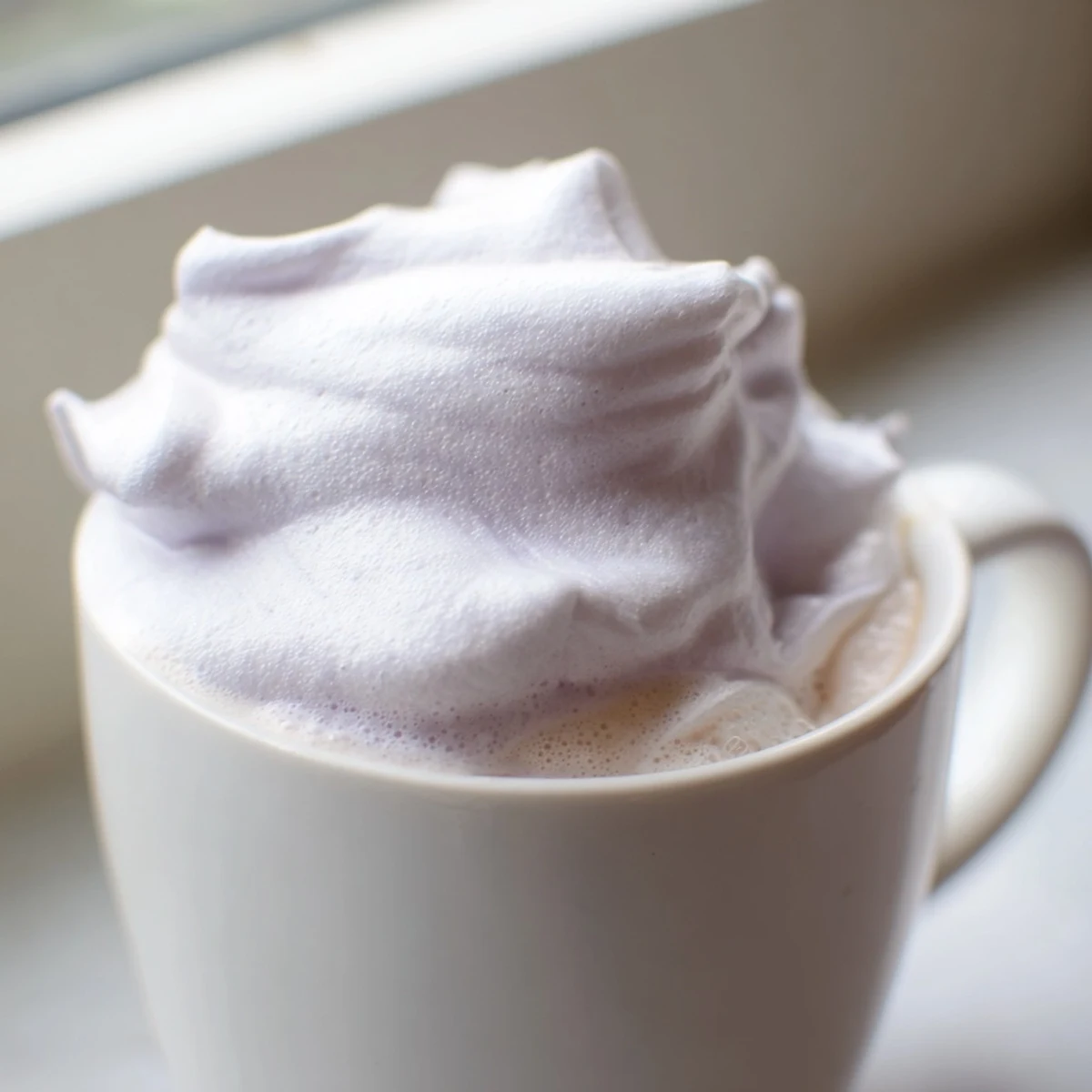 Steamed milk and espresso swirl together under a cloud of homemade lavender foam in this elegant Whipped Lavender Latte.  