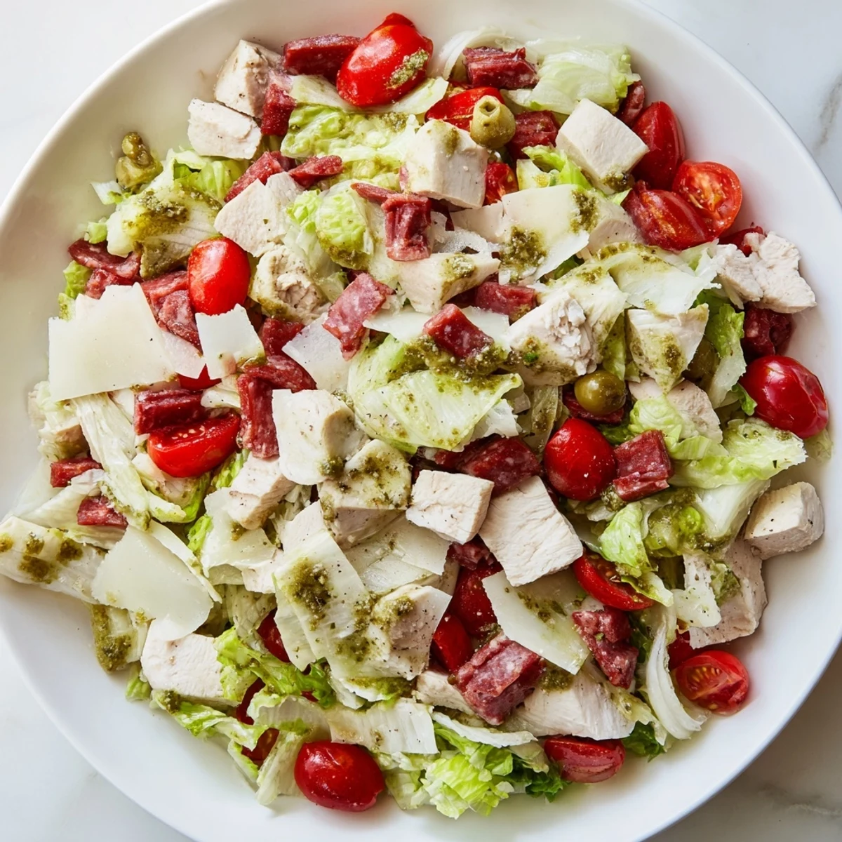 A vibrant bowl of Italian Deli Chopped Chicken Salad with pepperoncini and cucumber, tossed in a tangy herb dressing and ready to serve immediately.