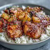 Pineapple Chicken and Rice Bake with Teriyaki Glaze in a golden, bubbly casserole dish, topped with fresh green onions and sesame seeds.
