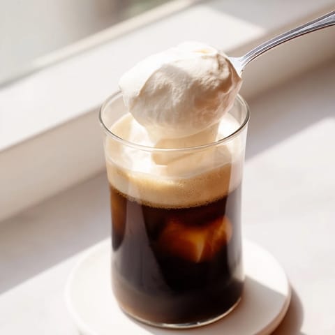 Creamy homemade Starbucks cold foam, perfectly aerated in a clear glass, ideal for delicious coffee.