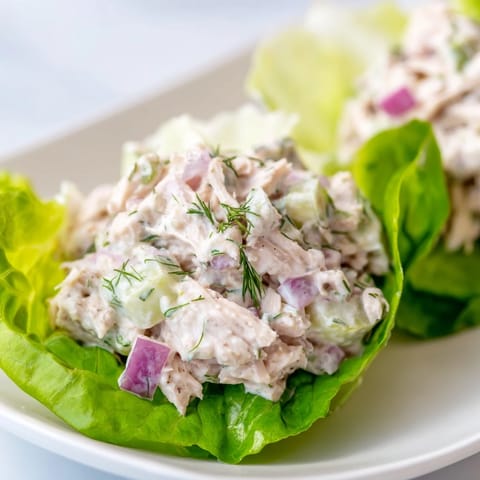 Dill Pickle Chicken Salad Lettuce Cups ready for a low carb lunch, garnished with fresh dill and diced red onion.