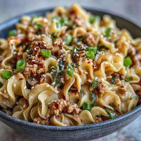 Creamy Potsticker Noodle Stir-Fry features ground turkey, ramen noodles, and coleslaw mix tossed in a rich, savory peanut-sesame sauce.