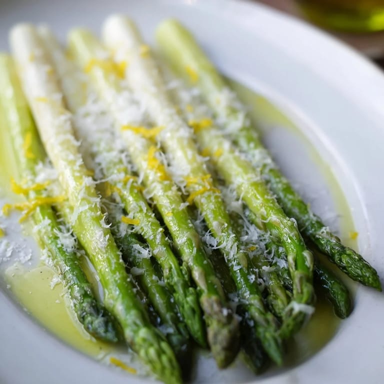 Close-up of vibrant roasted asparagus, speckled with Parmesan and lemon, perfect for a light meal.