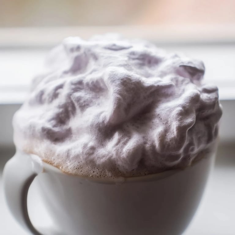 Enjoy a relaxing afternoon with this creamy Whipped Lavender Latte, topped with fluffy foam and served beside a buttery scone.
