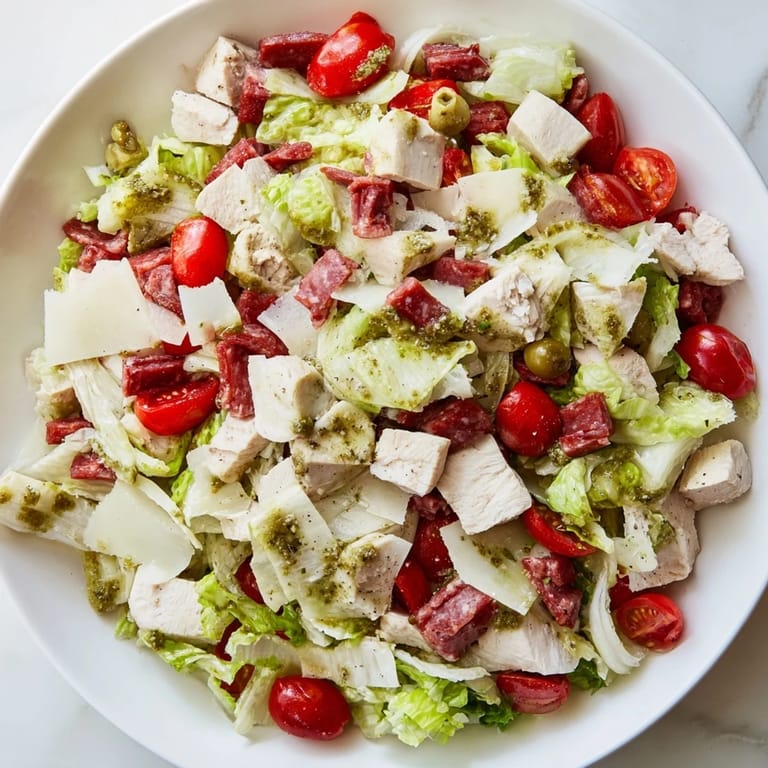 A vibrant bowl of Italian Deli Chopped Chicken Salad with pepperoncini and cucumber, tossed in a tangy herb dressing and ready to serve immediately.