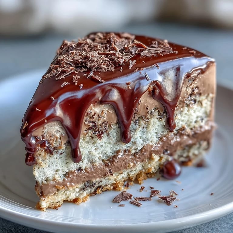 Close-up of Hojicha Butter Cream Cake garnished with chocolate shavings on a rustic plate.