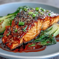 Miso Glazed Salmon with Sesame Bok Choy, golden and flaky, served alongside vibrant green, garlicky stalks.